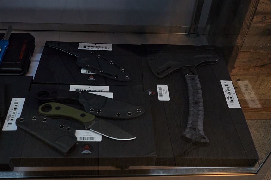 Fixed-blade knives and a hatchet in the display case