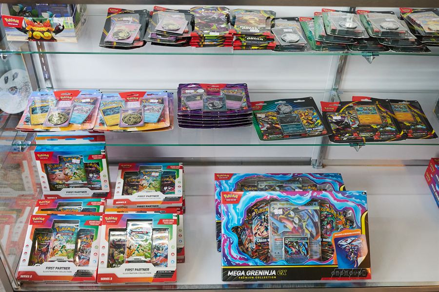 Pokémon collection boxes and tins in a glass case