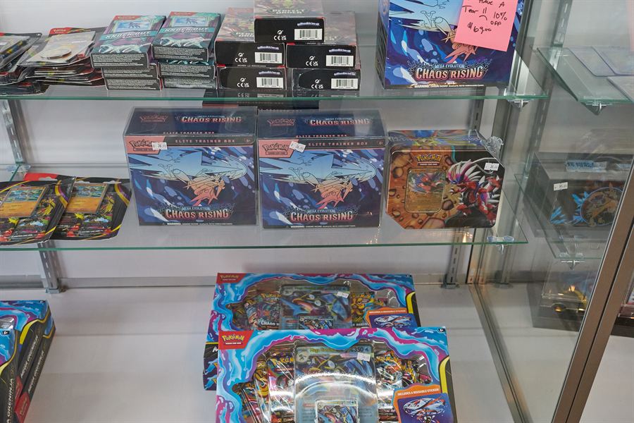 Sealed Pokémon booster boxes and bundles on glass shelves