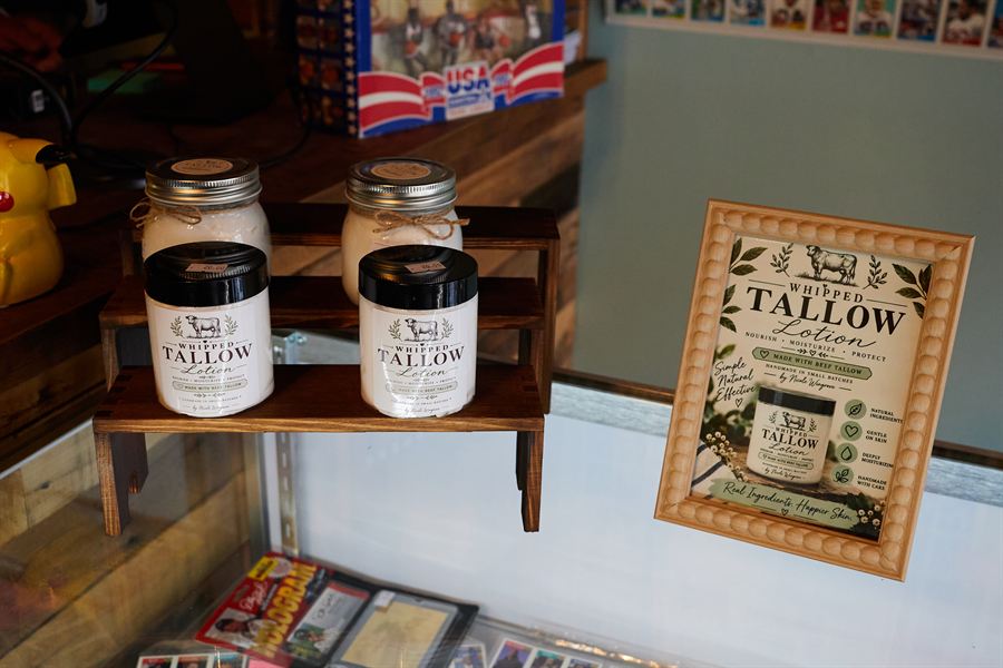 Jars of whipped tallow lotion on a wooden stand